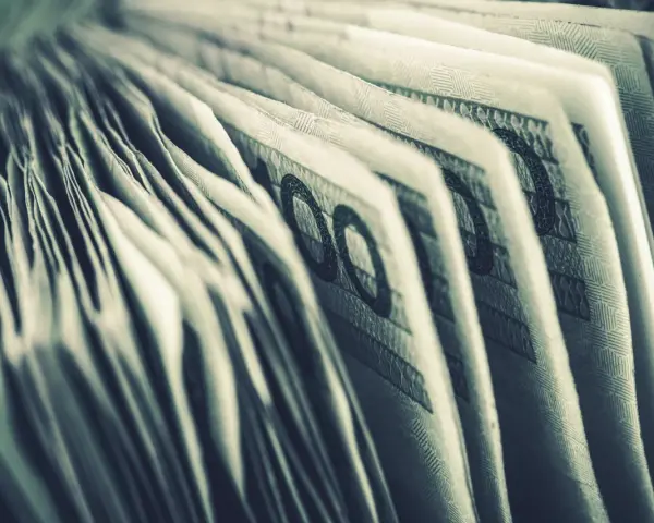 Zbliżenie na banknoty 100 zł. Widoczne detale i wzory, sugerujące zgromadzone środki, być może jako konto depozytowe osadzonego.