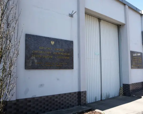 Tablica informacyjna przed budynkiem Krajowego Ośrodka Zapobiegania Zachowaniom Dyssocjalnym w Gostyninie.