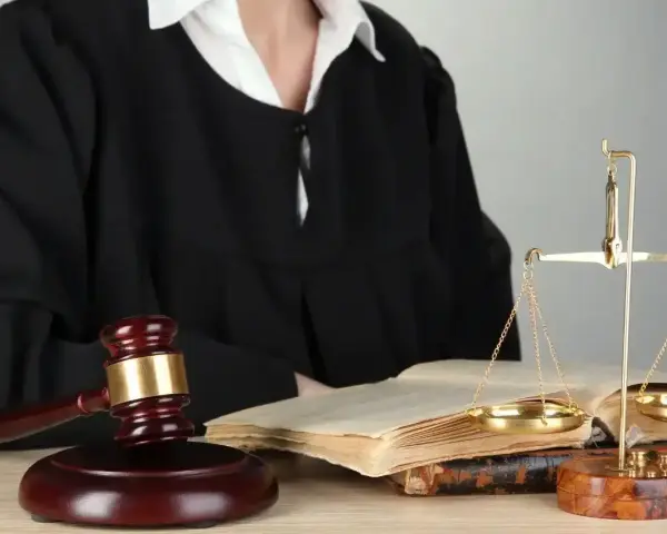 Sędzia w todze, młotek, waga sprawiedliwości i księgi symbolizują prawo i nadzwyczajne środki zaskarżenia.