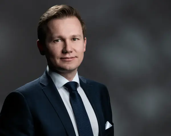 Mężczyzna w garniturze, gotowy do przesłuchania w charakterze świadka.