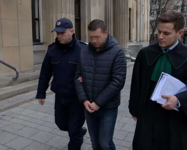 Policjant eskortuje podejrzanego przed budynkiem sądu. Ile jest więzień w Polsce? To pytanie nurtuje wielu.