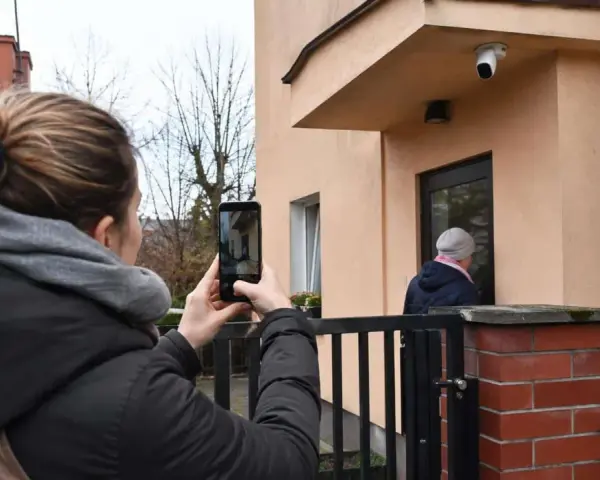 Kobieta nagrywa telefonem sytuację przed domem, zastanawiając się, czy nagranie z telefonu może być dowodem w sprawie karnej.