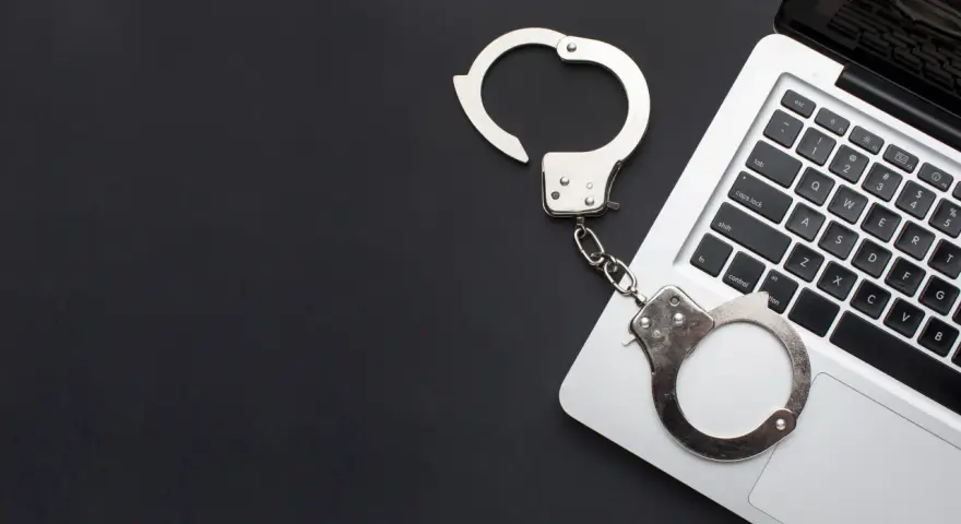 Kajdanki na klawiaturze laptopa, symbolizujące oświadczenie o podjęciu odbywania kary ograniczenia wolności wzór.