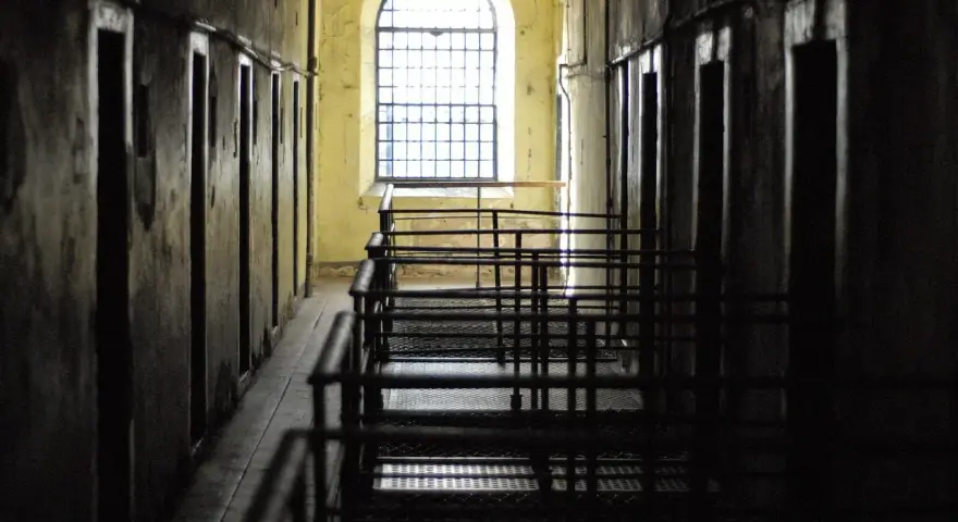 Korytarz więzienny z celami i kratami. Czekanie na decyzję sądu, po jakim czasie sąd wydaje nakaz doprowadzenia do zakładu karnego, może być długie.