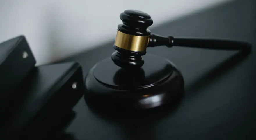 Młotek sędziowski i akta prawne symbolizują sprawiedliwość w sprawach o przestępstwo skarbowe.