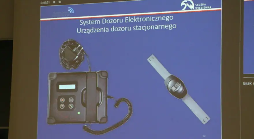 System dozoru elektronicznego, urządzenie stacjonarne i opaska. Może być używane do wynajmu mieszkania z dozorem.