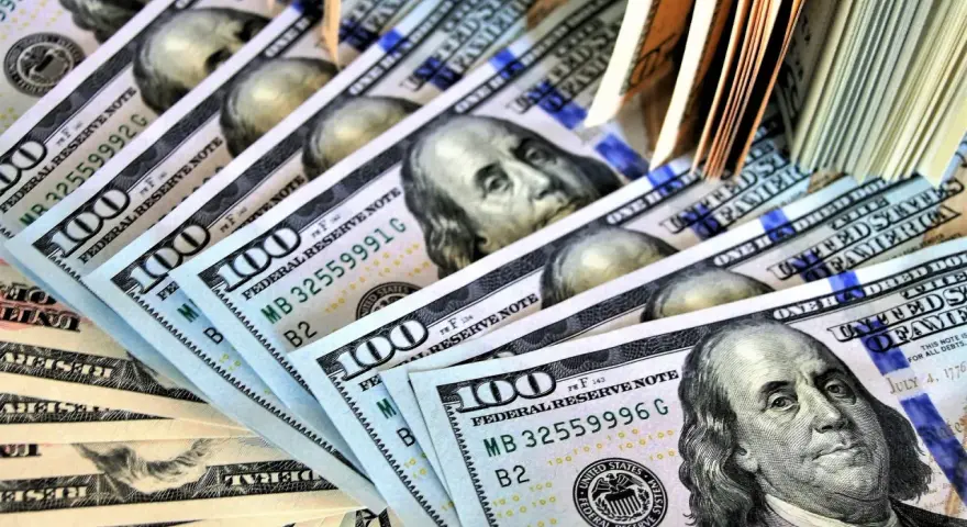 Stos banknotów 100-dolarowych, symbolizujących zabezpieczenie majątkowe w postępowaniu karnym.