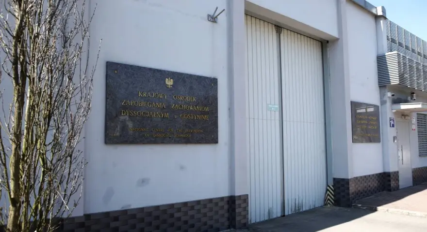 Tablica informacyjna przed budynkiem Krajowego Ośrodka Zapobiegania Zachowaniom Dyssocjalnym w Gostyninie.