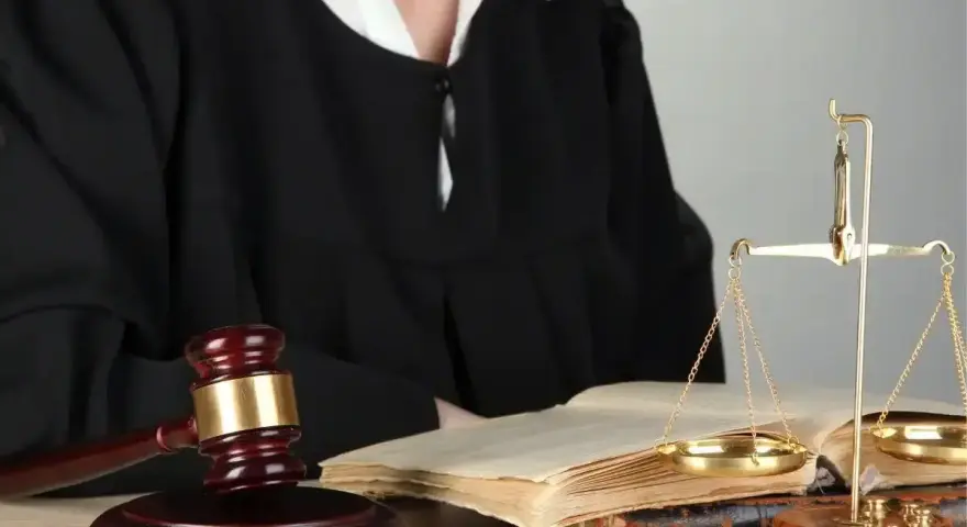 Sędzia w todze, młotek, waga sprawiedliwości i księgi symbolizują prawo i nadzwyczajne środki zaskarżenia.