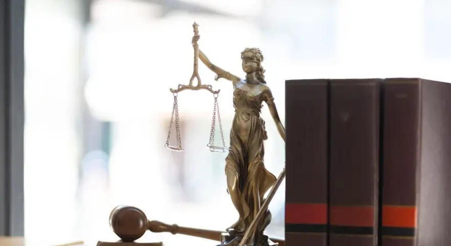 Temida, waga i młotek sędziowski symbolizują prawo. Zasady wyjścia za kaucją są tu kluczowe.