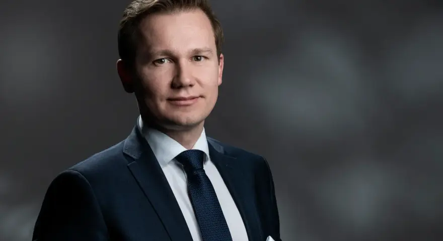 Mężczyzna w garniturze, gotowy do przesłuchania w charakterze świadka.