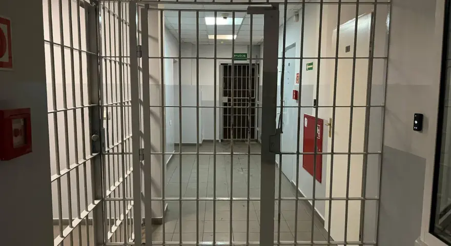 Korytarz więzienny z kratami, gdzie każdy krok może prowadzić do spotkania z niebezpiecznym więźniem.