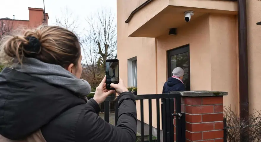 Kobieta nagrywa telefonem sytuację przed domem, zastanawiając się, czy nagranie z telefonu może być dowodem w sprawie karnej.