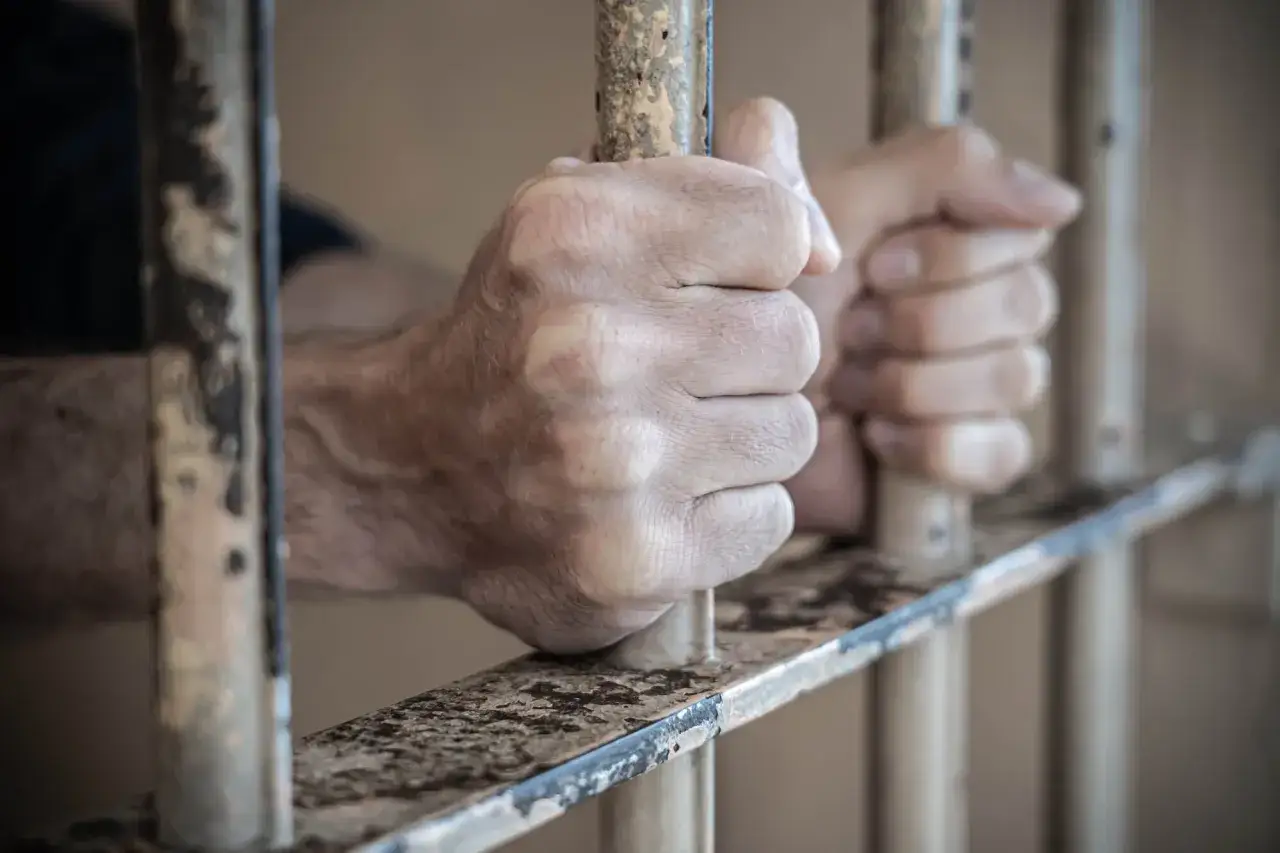 Dłonie skazanego mocno zaciskają się na kratach więziennych. To obraz, który może posłużyć jako wzór do oceny jego stanu psychicznego.