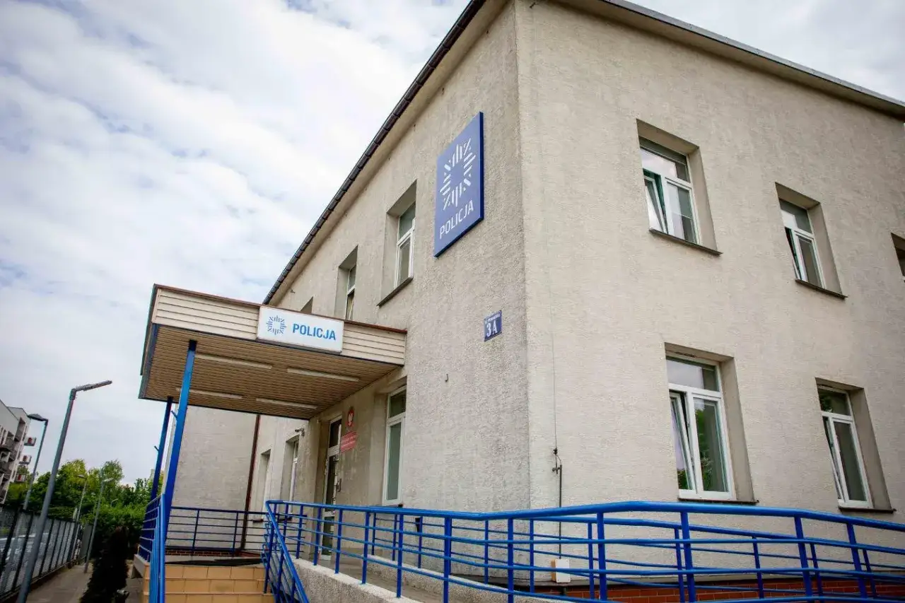 Budynek policji, gdzie zgłoszono podejrzenie popełnienia przestępstwa. Niebieskie balustrady prowadzą do wejścia.