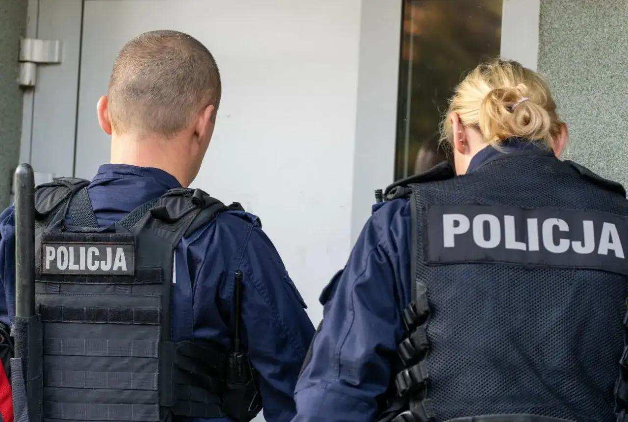 Dwóch policjantów w kamizelkach taktycznych. Czekają na decyzję sądu, po jakim czasie sąd wydaje nakaz doprowadzenia do zakładu karnego.