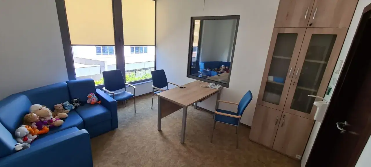 Pokój terapeutyczny z pluszakami na kanapie, przygotowany do przesłuchania osób chorych psychicznie.