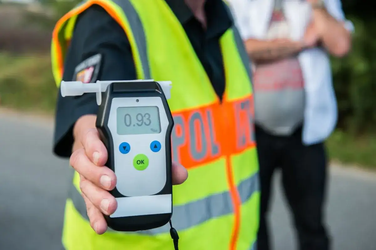 Policjant pokazuje alkomat z wynikiem 0.93‰. To badanie alkomatem się liczy, by zapewnić bezpieczeństwo na drogach.