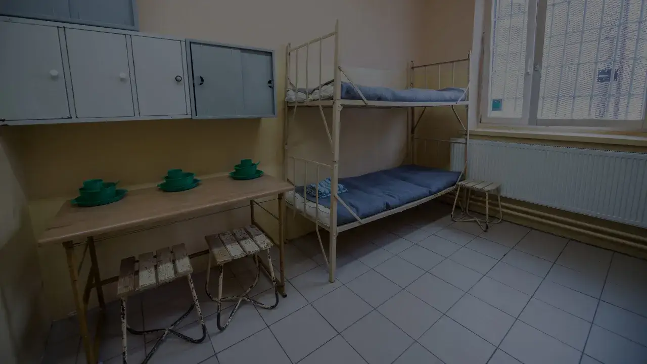 Proste łóżko piętrowe, stół z krzesłami i szafki w celi. Dowiedz się, jak wysłać pieniądze do zakładu karnego.