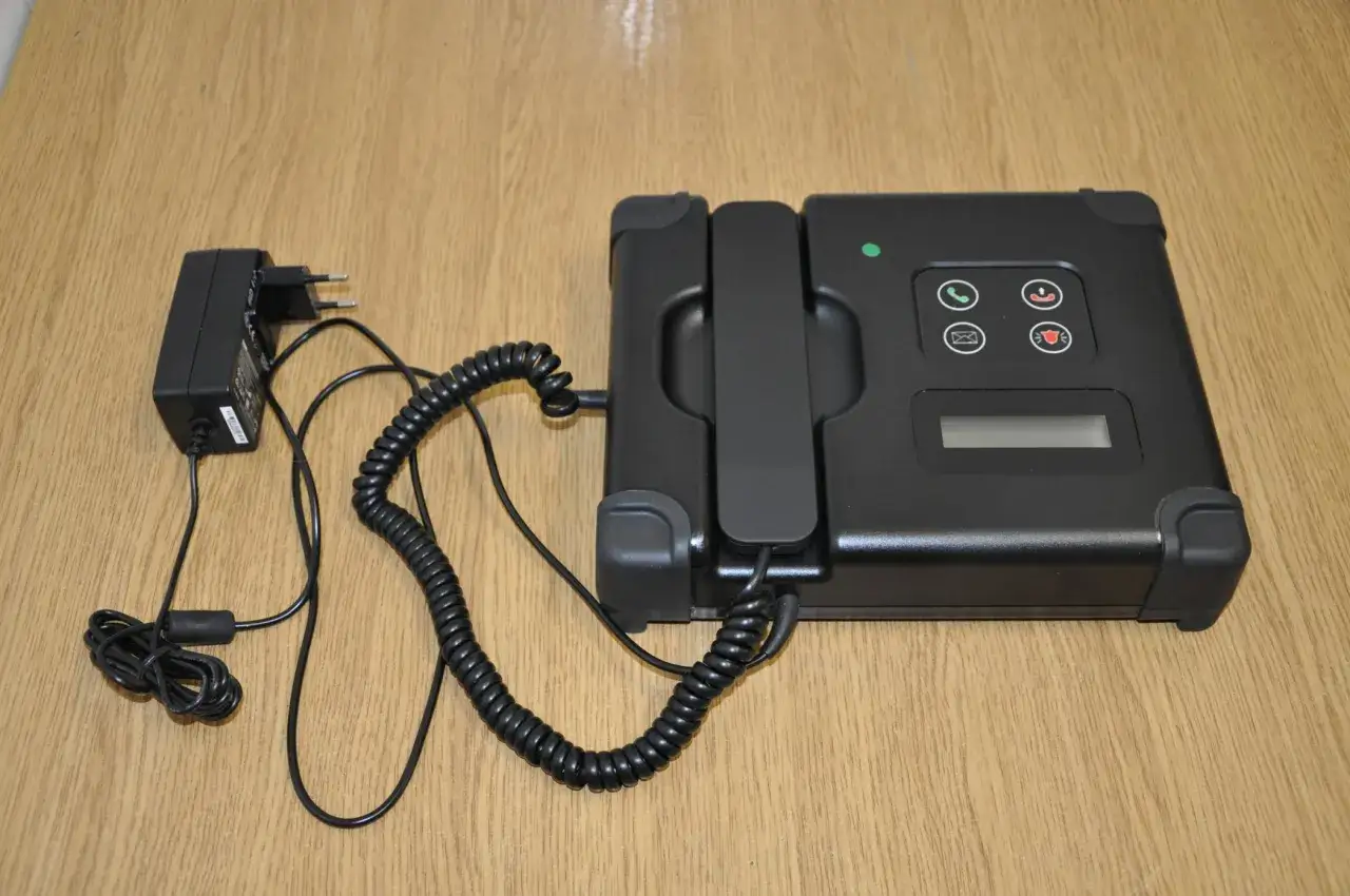 Czarny telefon zasilany przez adapter, część systemu dozoru elektronicznego do 1,5 roku od kiedy.
